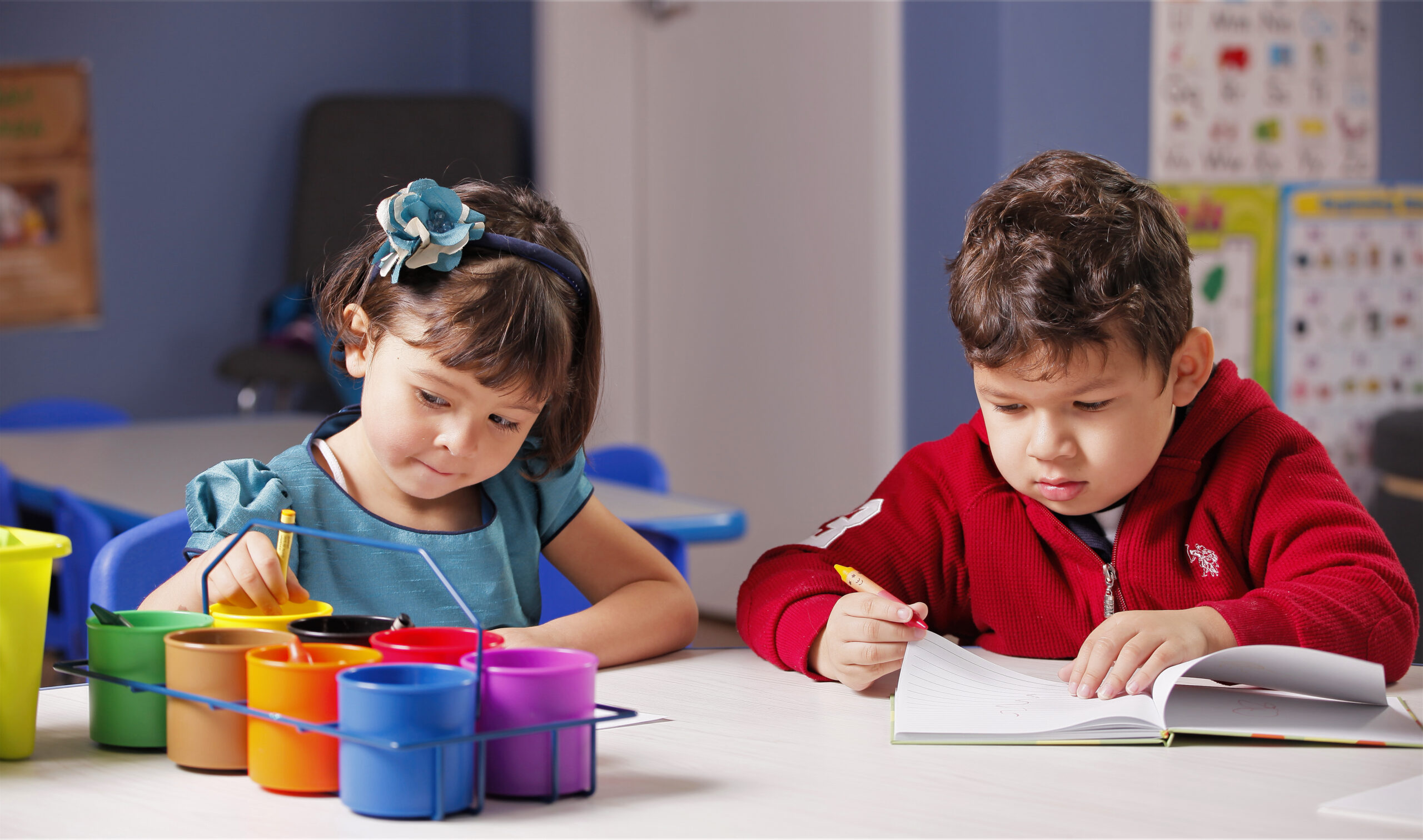 2 kids drawing with crayons